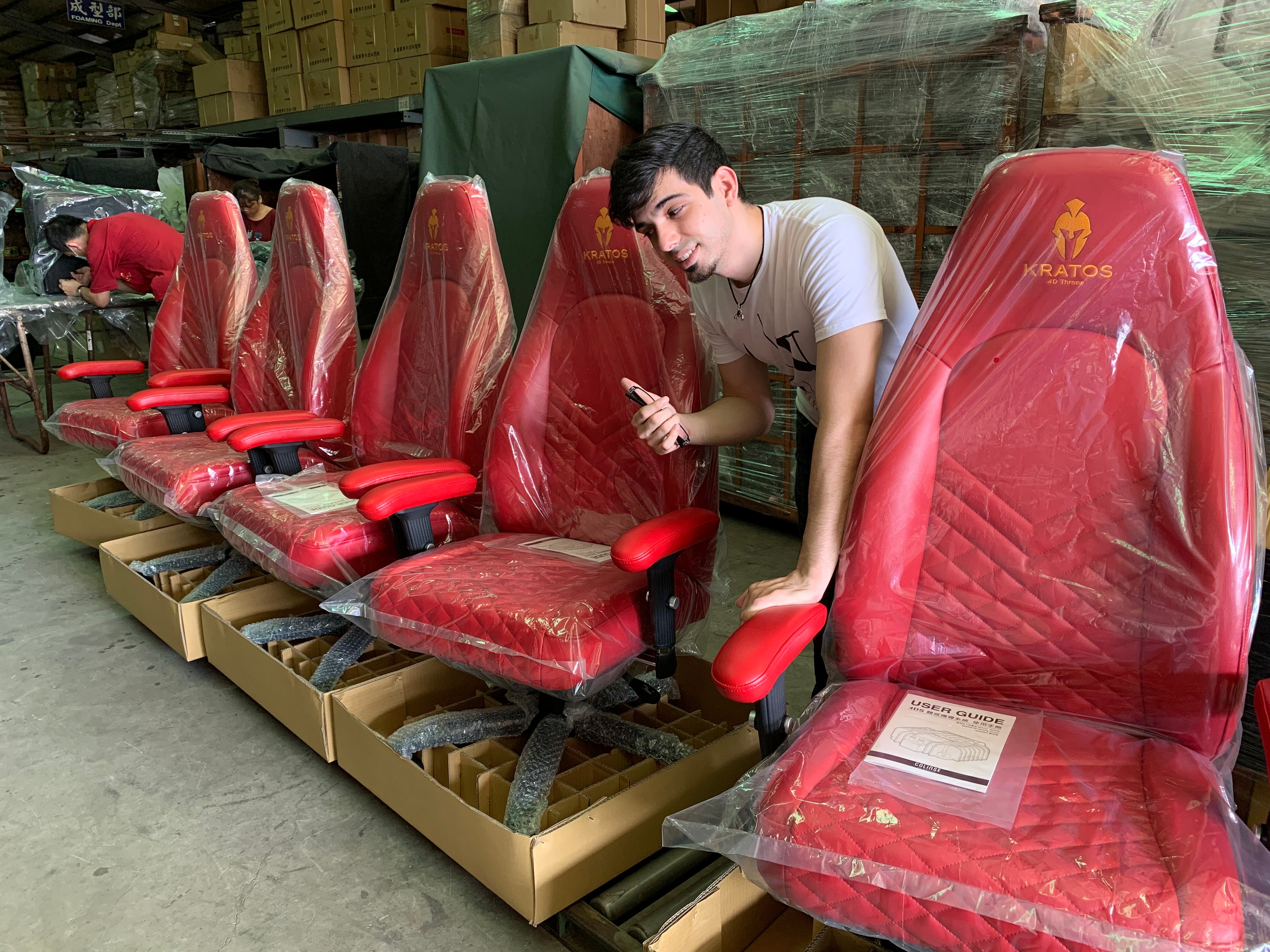 Carlos Fernandez CO-Founder of Kratos Haptic Gaming Chairs with 5 Red Gaming chairs next to him